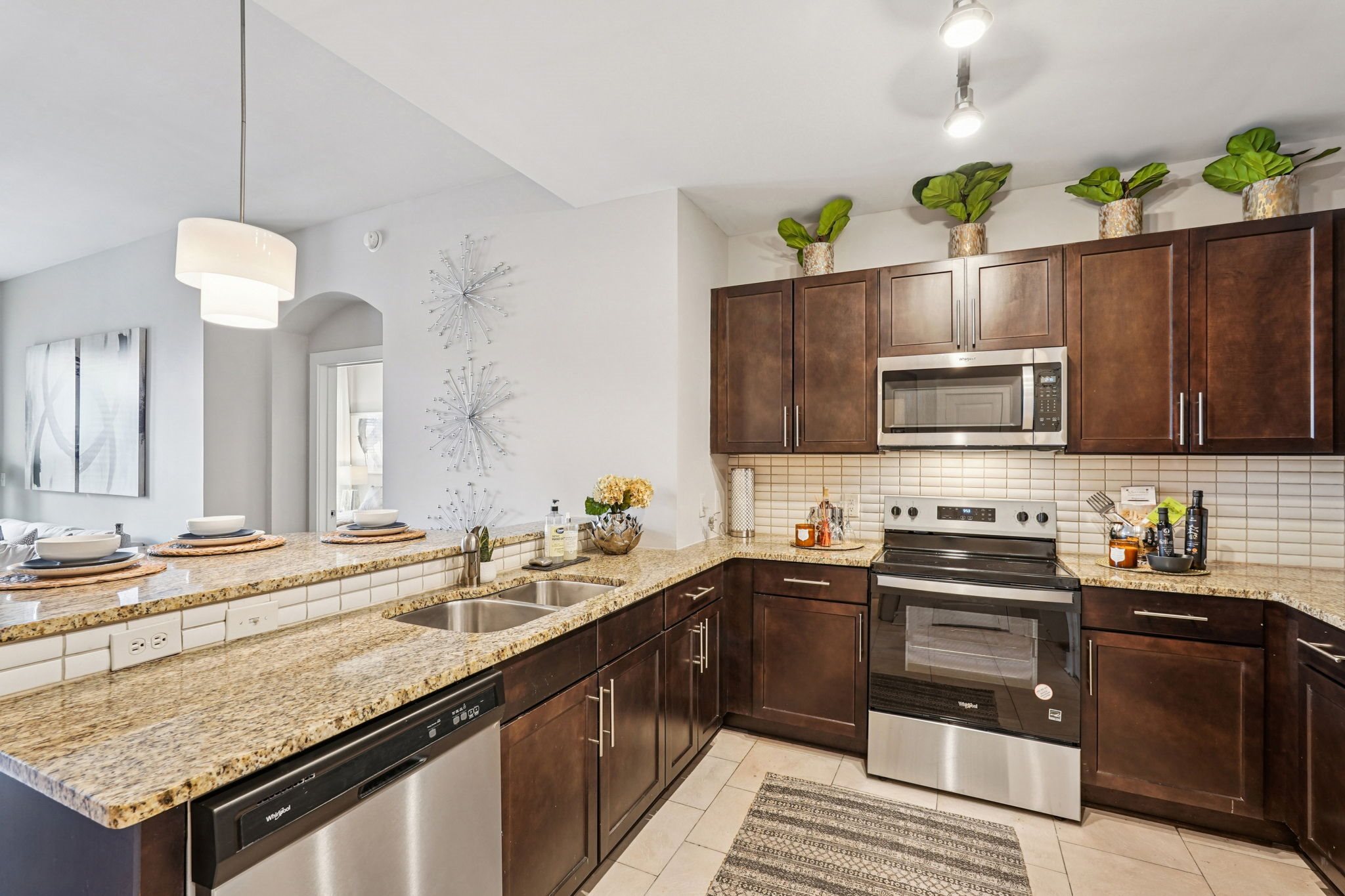 A modern kitchen with brown cabinets and stainless steel appliances.